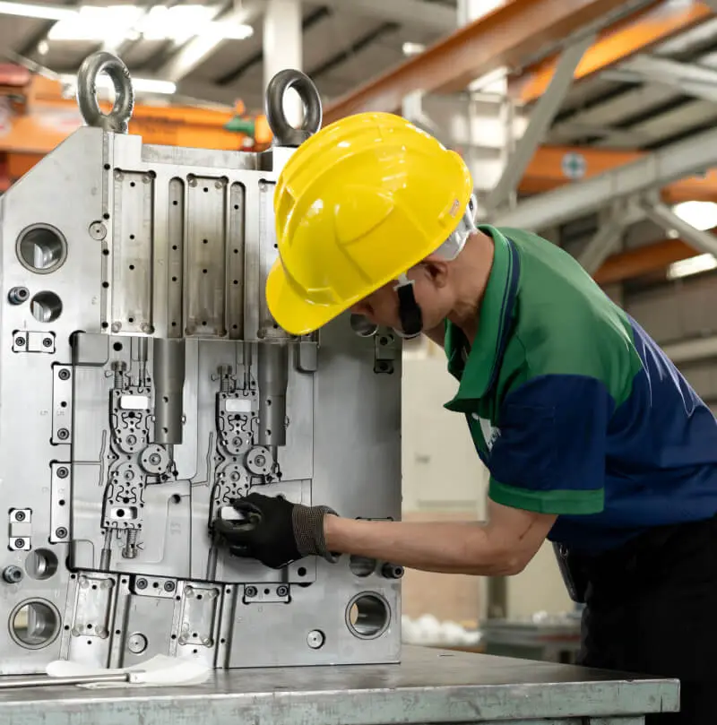 AMP technician inspecting a multi-cavity mold during assembly and trial