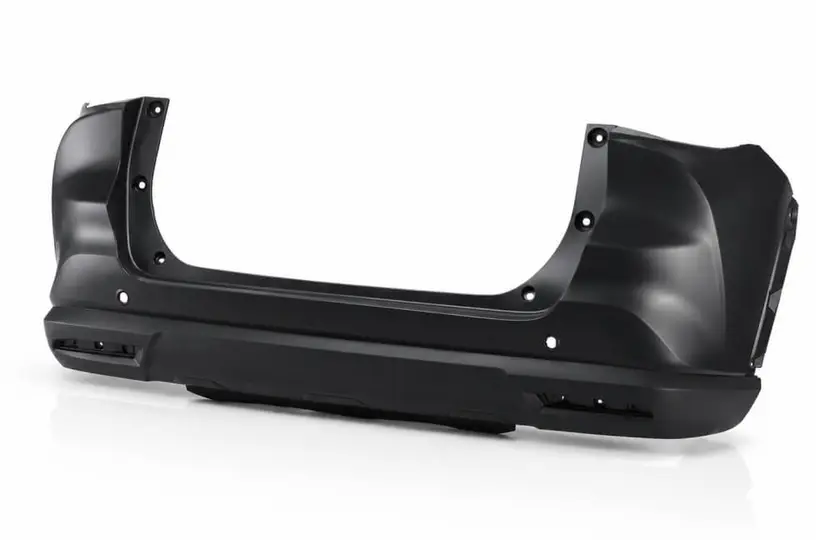 Black injection molded rear bumper for an SUV on a white background