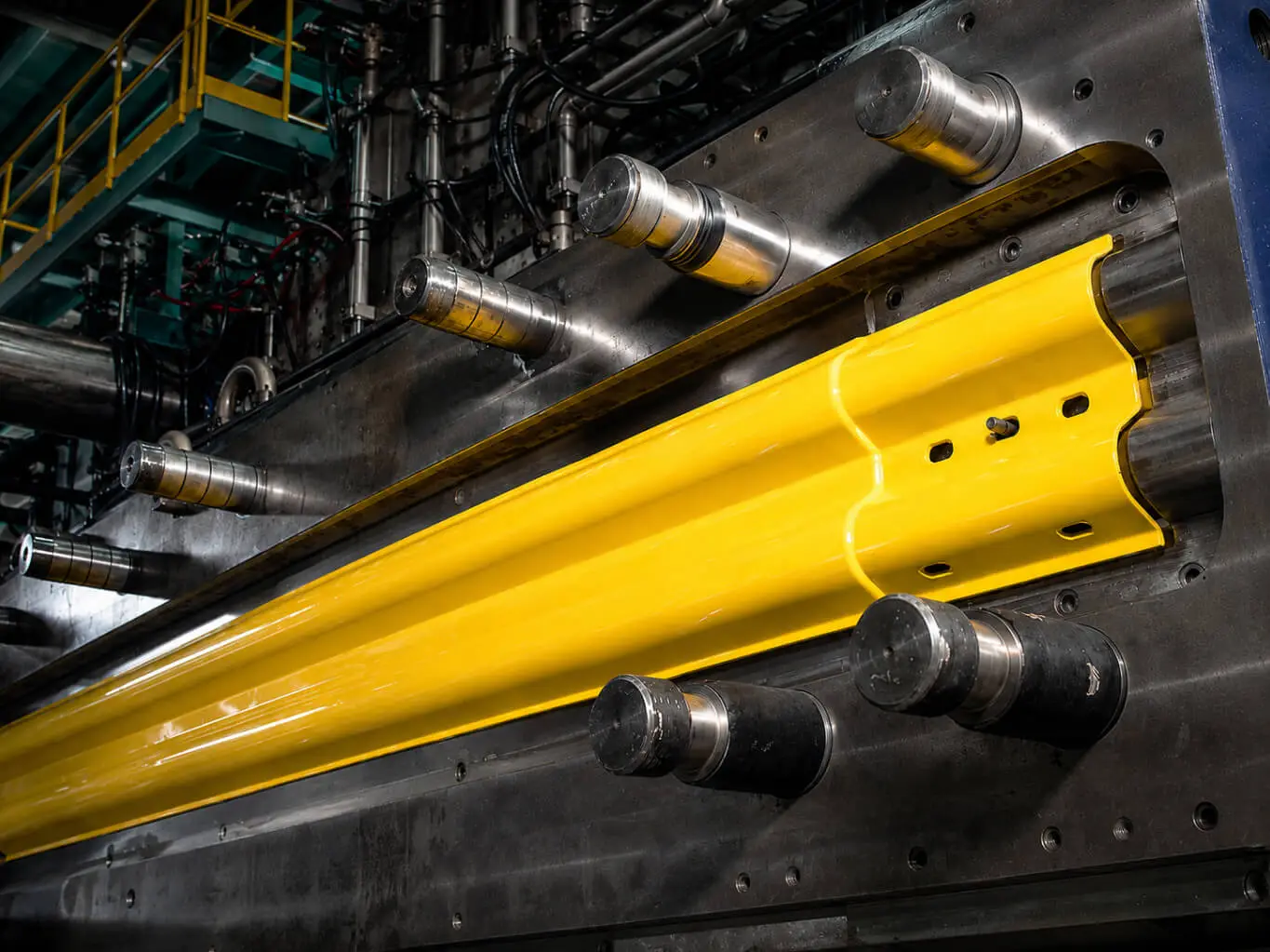 Yellow ASP polycarbonate W-profile guardrail section in an injection molding machine at AMP Taiwan