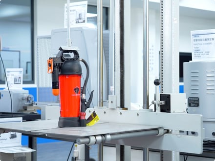 Eco Elephant extinguisher positioned on an AMP test fixture for controlled mechanical evaluation in the quality lab