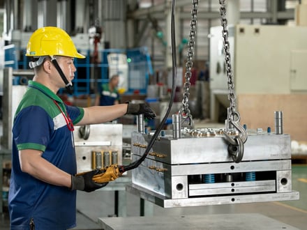AMP toolmaker positioning a fully assembled export mold via overhead crane, moving it to trial on our injection molding machines before shipment to your facility