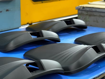 AMP injection-molded seat outer panels with textured matte finish, staged for inspection after production on our press fleet