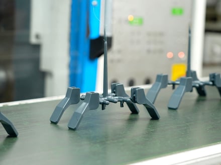 AMP injection-molded precision components still attached to the runner system after ejection from a multi-cavity mold, ready for degating