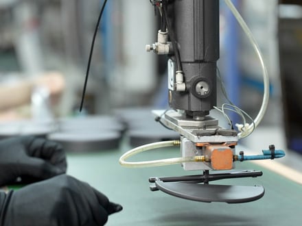AMP robotic arm placing injection-molded components onto the conveyor after automated extraction from the press