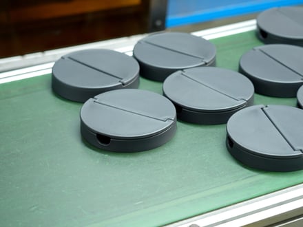 AMP injection-molded precision components with consistent surface finish on the production conveyor, ready for inspection and packaging