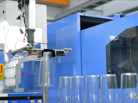 AMP robotic extraction placing clear injection-molded components from a JSW press, produced in optically transparent material for consumer or food and beverage applications
