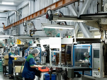 AMP operators running small-tonnage injection molding machines with robotic part extraction, producing precision components for OEM programs