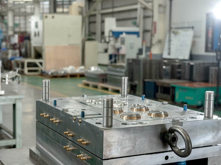 AMP-assembled multi-cavity injection mold with guide pins, cooling fittings, and cavity inserts on our tooling floor, ready to move to trial
