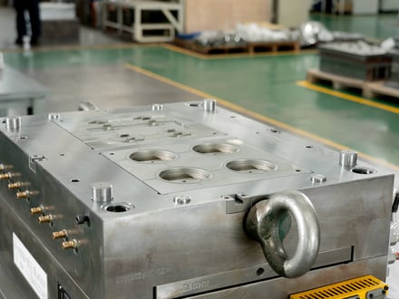 AMP-assembled multi-cavity injection mold with cooling fittings and lifting eye, staged on our tooling floor after assembly and before trial