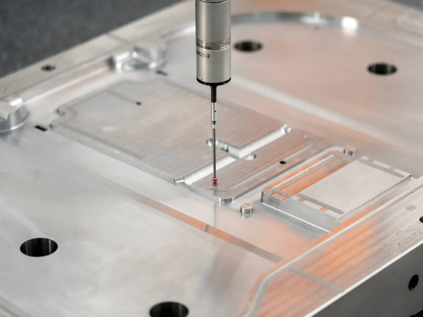 AMP CMM probe verifying critical dimensions on a precision-machined mold component in our in-house quality lab