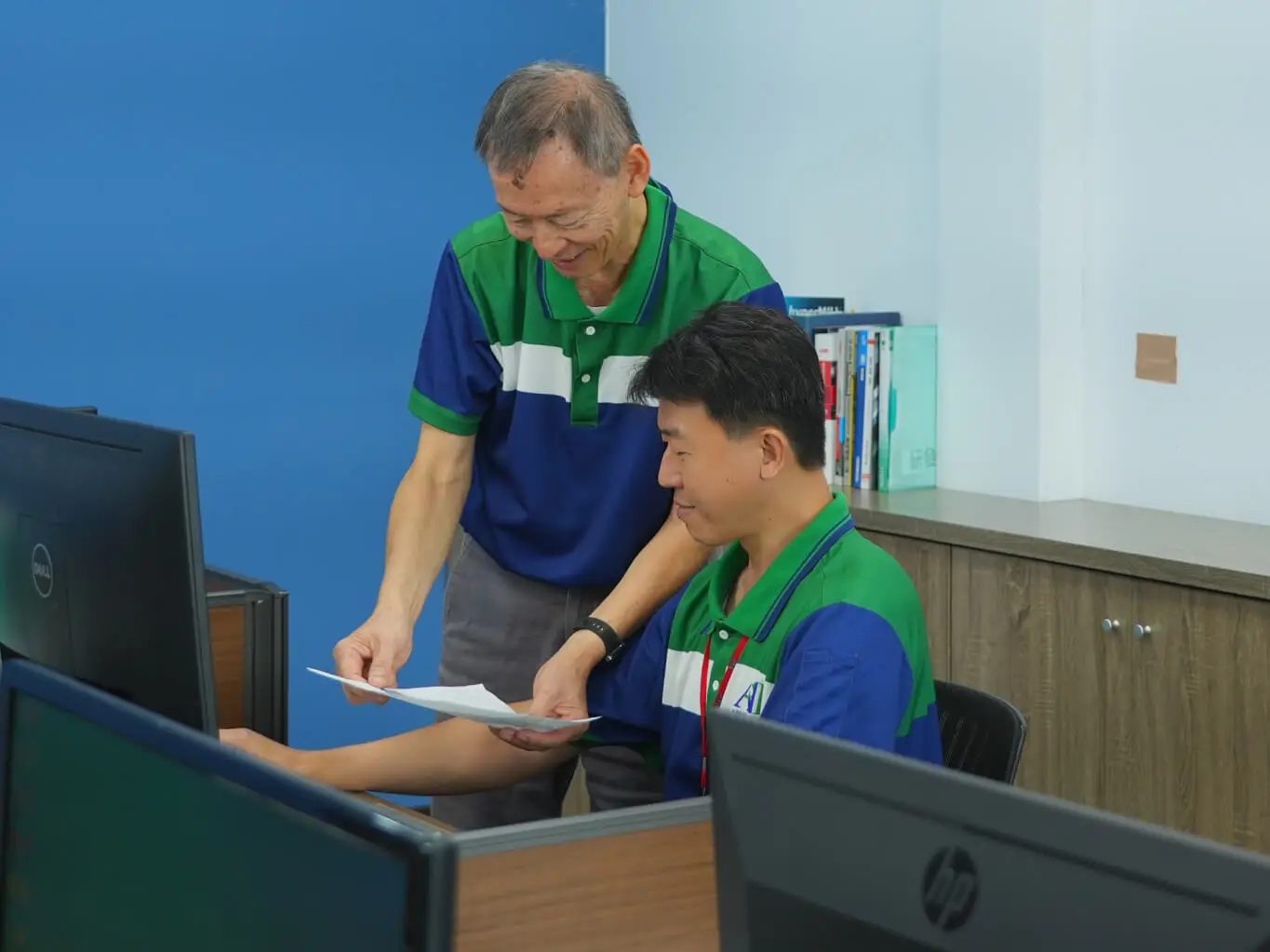 AMP R&D engineers reviewing product and mold design documents together at a workstation in our Taiwan facility
