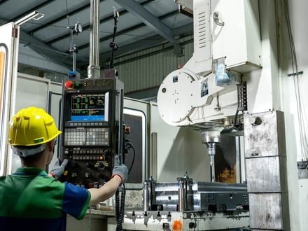 AMP operator programming a FANUC-controlled CNC machine during mold base machining at our in-house tooling facility