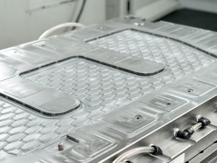 AMP-machined automotive floor mat mold with textured tread pattern and cooling lines, ready for injection molding production